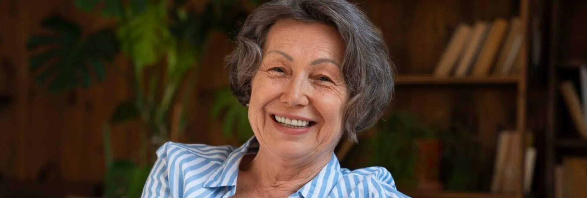 Mujer sonriendo mientras revisa documentos financieros, representando confianza.